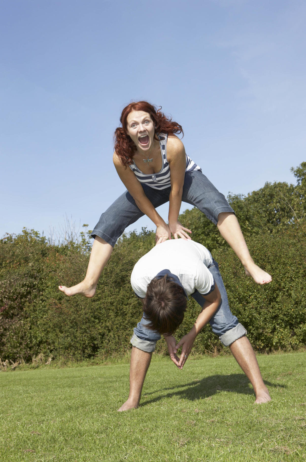 Portrait of woman jumping over the top of man (Flashpop / Getty Images)