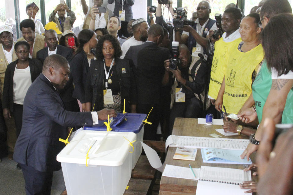 Mozambican President Felipe Nyusi, bottom left, casts his vote in Maputo, Mozambique Tuesday, Oct. 15, 2019 in the country's presidential, parliamentary and provincial elections. Polling stations opened across the country with 13 million voters registered to cast ballots in elections seen as key to consolidating peace in the southern African nation. (AP Photo/Ferhat Momade)