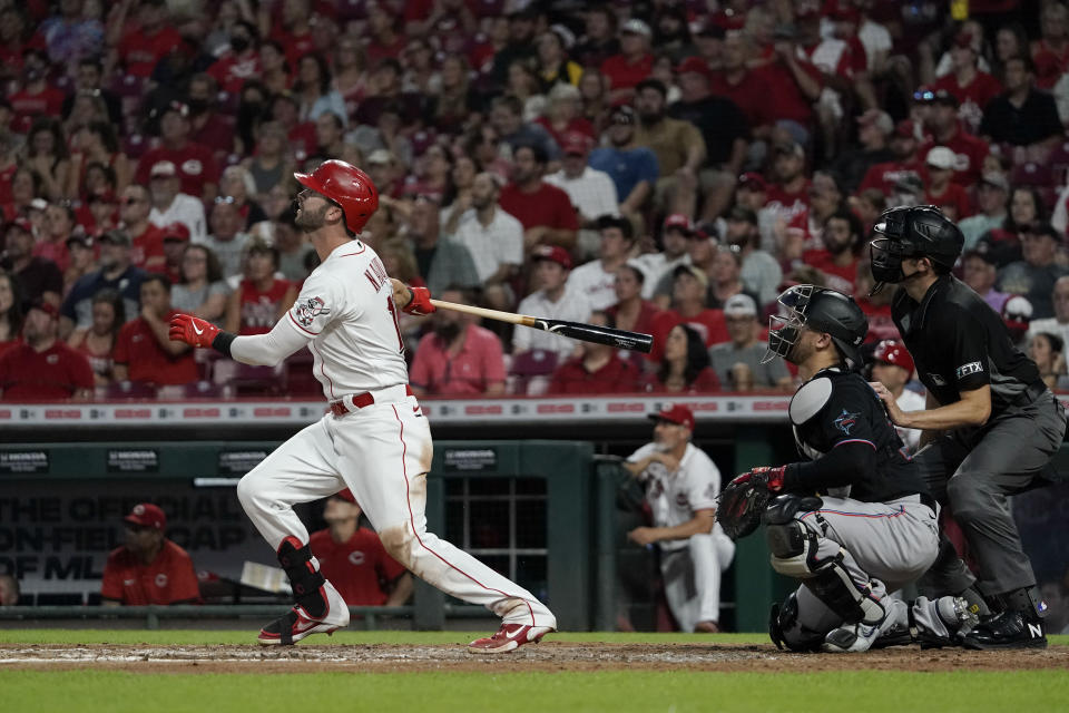 Cincinnati Reds' Tyler Naquin, left, watches his solo home run during the fifth inning of a baseball game against the Miami Marlins, Friday, Aug. 20, 2021, in Cincinnati. (AP Photo/Jeff Dean)