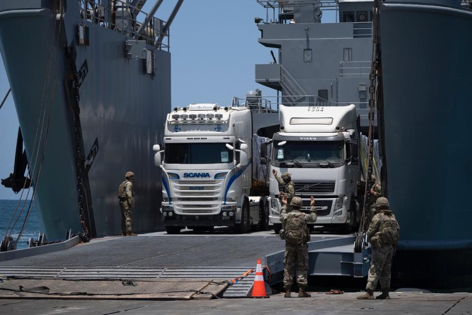 運送救援物資的貨車25日經由美軍搭建的浮動碼頭，將物資送上岸。美聯社