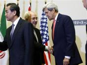 U.S. Secretary of State John Kerry (R) shakes hands with Iranian Foreign Minister Mohammad Javad Zarif after a ceremony at the United Nations in Geneva November 24, 2013. REUTERS/Denis Balibouse