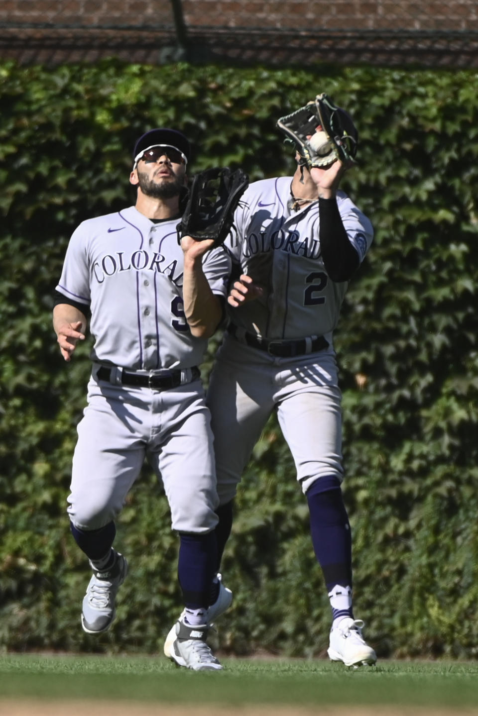 Colorado Rockies center fielder Yonathan Daza (2) catches a fly ball hit by Chicago Cubs' Ian Happ as left fielder Connor Joe (9) looks on, during the fifth inning of a baseball game, in Chicago, Sunday, Sept. 18, 2022. (AP Photo/Matt Marton)