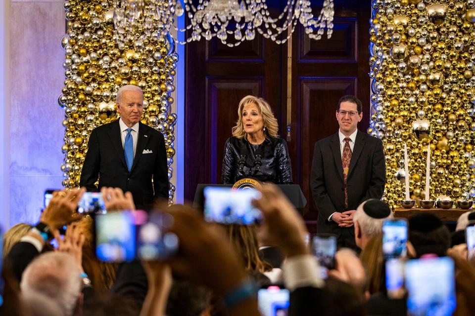 First Lady Dr. Jill Biden (C) speaks alongside US President Joe Biden (L) and Rabbi Charlie Cytron-Walker during a Hanukkah Holiday Reception in the Grand Foyer of the White House