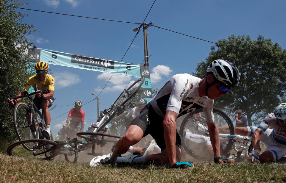 Team Sky rider Chris Froome of Britain crashes as BMC Racing Team rider Greg Van Avermaet of Belgium in the overall leader’s yellow jersey escapes the crash. (Reuters).