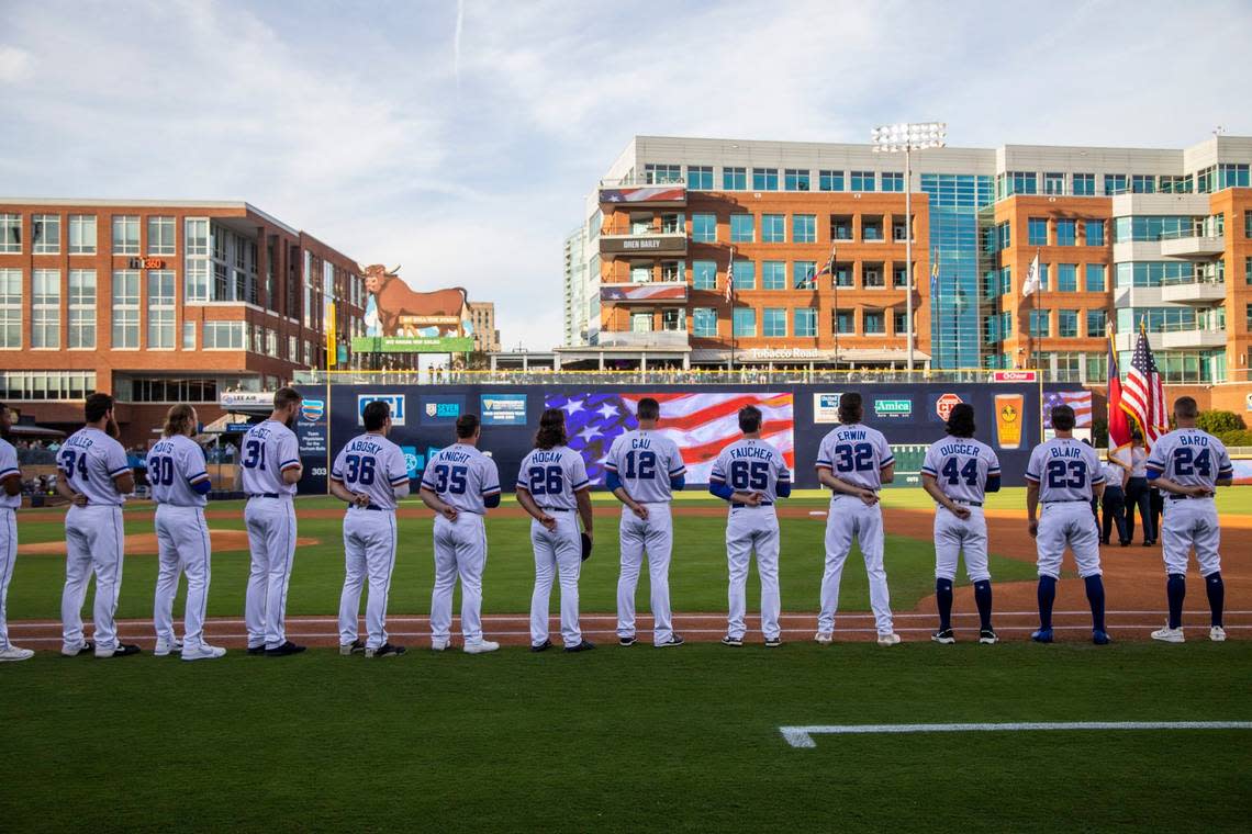 The Durham Bulls stand for the National Anthem prior to the Bulls season opener against the Jacksonville Jumbo Shrimp at the Durham Bulls Athletic Park, Tuesday, April 12, 2022.
