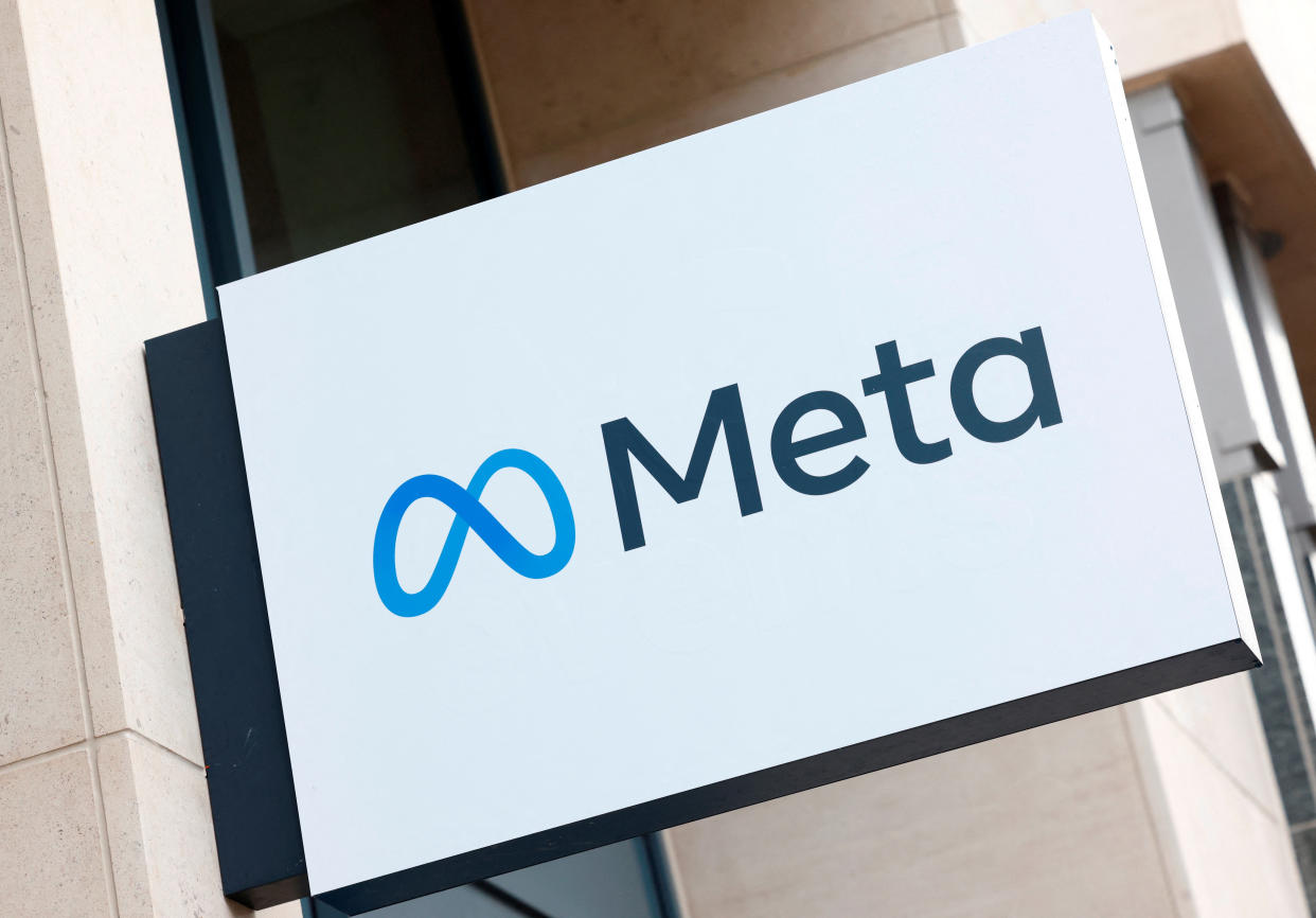 The Meta logo is seen on a sign attached to a building.