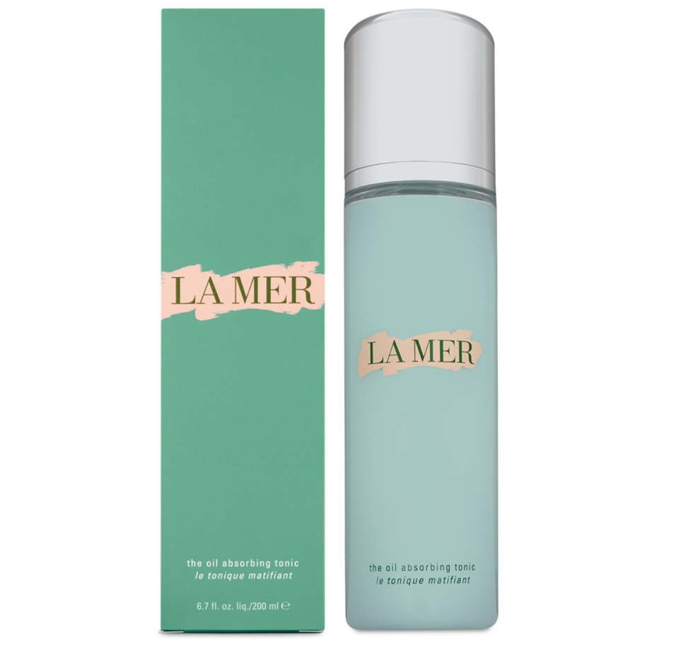 Bottle of La Mer The Oil Absorbing Tonic in green and silver, next to its green and gold packaging