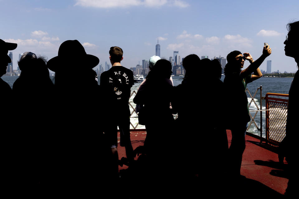 People photograph the Manhattan skyline aboard the Staten Island Ferry, Thursday, Aug. 4, 2022, in New York. (AP Photo/Julia Nikhinson)