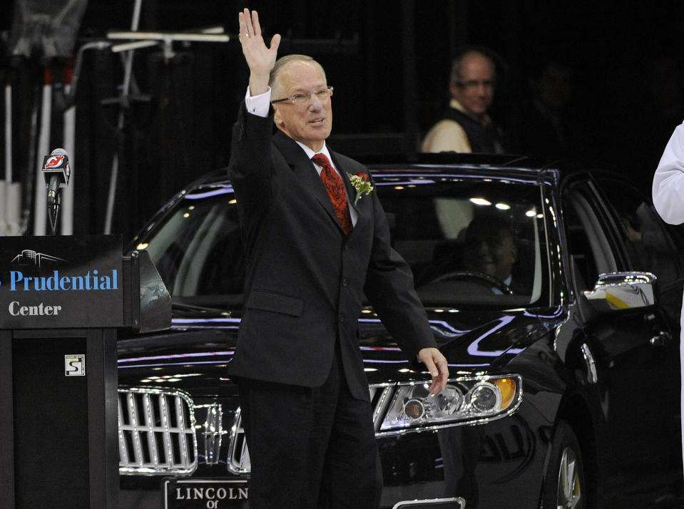 FILE - In this Feb. 24, 2012, file photo, sports commentator Mike "Doc" Emrick waves to fans as he is presented with a car from the New Jersey Devils during a ceremony to honor him before their NHL hockey game against the Vancouver Canucks, in Newark, N.J. Hall of Fame hockey broadcaster Mike Emrick is retiring after a career of almost 50 years behind the microphone, including the past 15 as the voice of the NHL in the United States. (AP Photo/Bill Kostroun, File)