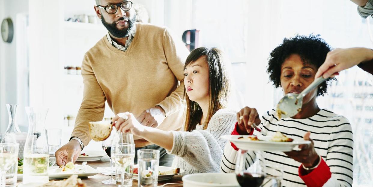 order thanksgiving dinner 2022  family passing food around at thanksgiving dinner table