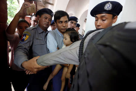 Detained Reuters journalist Kyaw Soe Oo, handcuffed, carries his daughter Moe Thin Wai Zin while arriving at a court hearing in Yangon, Myanmar May 16, 2018. REUTERS/Ann Wang