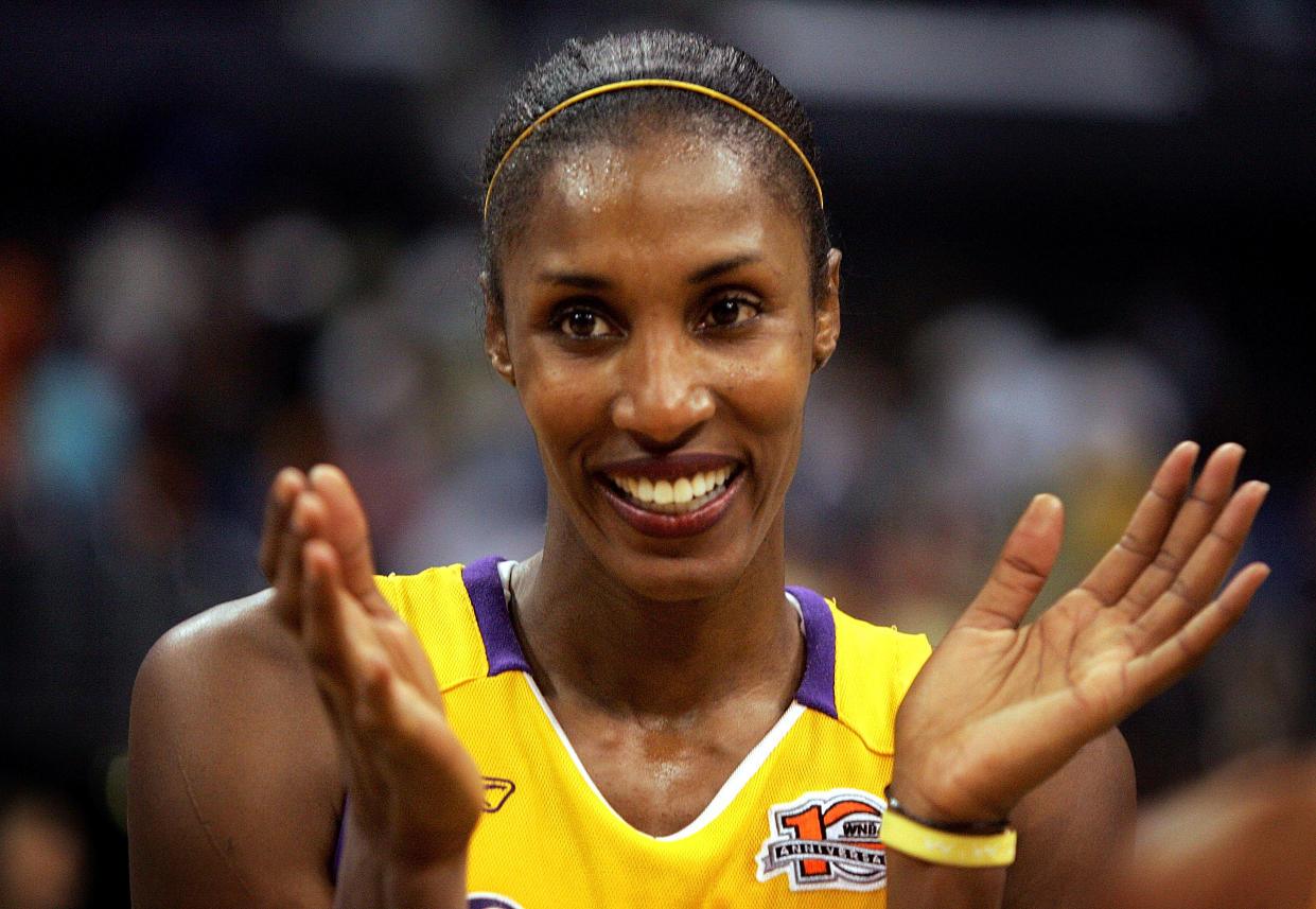 Lisa Leslie smiles and claps her hands in celebration.