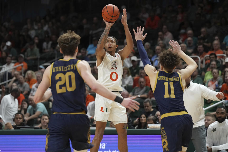 Miami guard Matthew Cleveland (0) takes a shot as Notre Dame guard Braeden Shrewsberry (11) and guard J.R. Konieczny (20) close in during the first half of an NCAA college basketball game, Saturday, Dec. 2, 2023, in Coral Gables, Fla. (AP Photo/Jim Rassol)