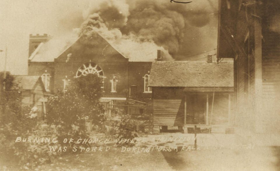 In this photo provided by the Department of Special Collections, McFarlin Library, The University of Tulsa, the Mt. Zion Baptist Church burns during the Tulsa Race Massacre in Tulsa, Okla., on June 1, 1921. (Department of Special Collections, McFarlin Library, The University of Tulsa via AP)