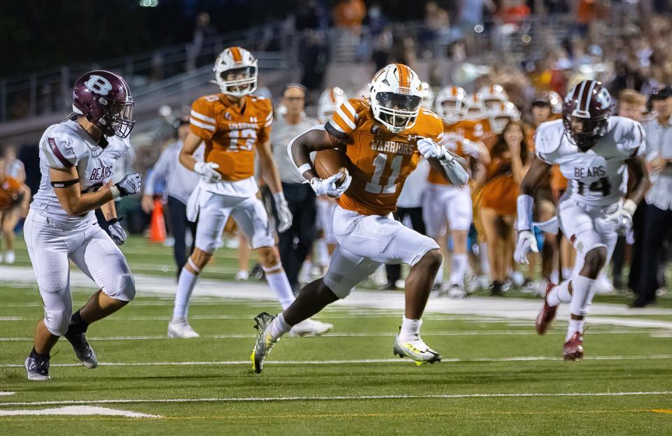 Westwood's Demani Stewart carries the ball for extra yards during the Warriors' 49-42 overtime win over Bastrop on Friday. Stewart rushed for 214 yards and three touchdowns on just 16 carries.