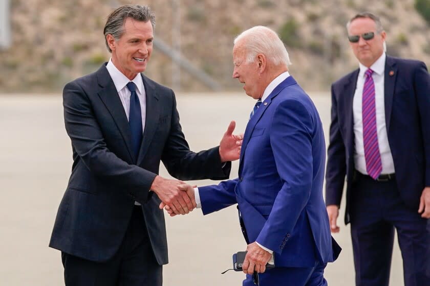 President Joe Biden, right, greets California Gov. Gavin Newsom after arriving at Los Angeles International Airport