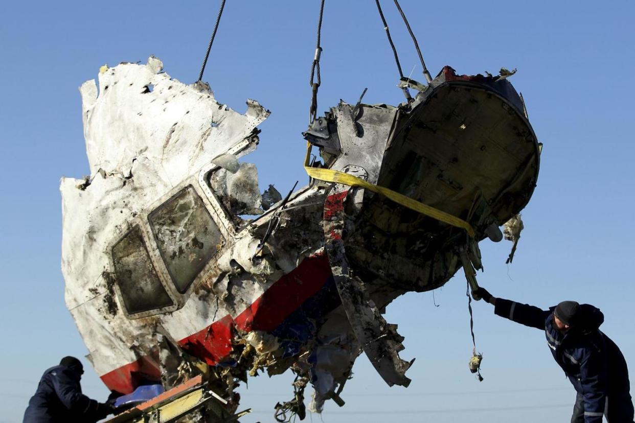 Workers transport a piece of the Malaysia Airlines flight MH17 wreckage at the site of the plane crash in 2014