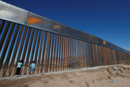 Children play at a newly built section of the U.S.-Mexico border wall at Sunland Park, U.S. opposite the Mexican border city of Ciudad Juarez, Mexico November 18, 2016. Picture taken from the Mexico side of the U.S.-Mexico border. Picture taken November 18, 2016. REUTERS/Jose Luis Gonzalez