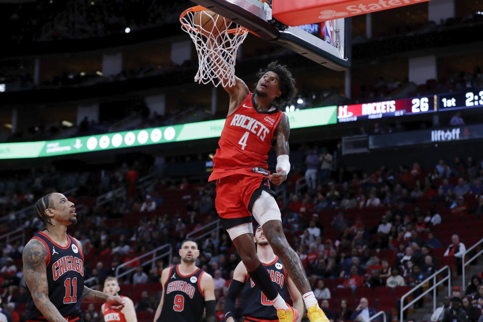 Houston Rockets guard Jalen Green (4) dunks over Chicago Bulls forward DeMar DeRozan (11), center Nikola Vucevic (9), and guard Alex Caruso, back right, during the first half of an NBA basketball game Thursday, March 21, 2024, in Houston. (AP Photo/Michael Wyke)