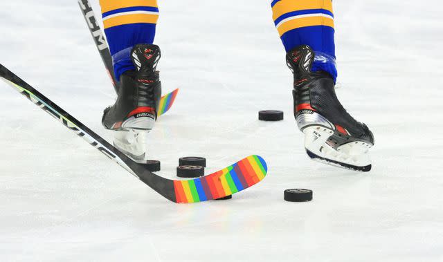 <p> Bill Wippert/NHLI via Getty</p> Buffalo Sabres warm up with rainbow-colored tape on their sticks for Pride Night