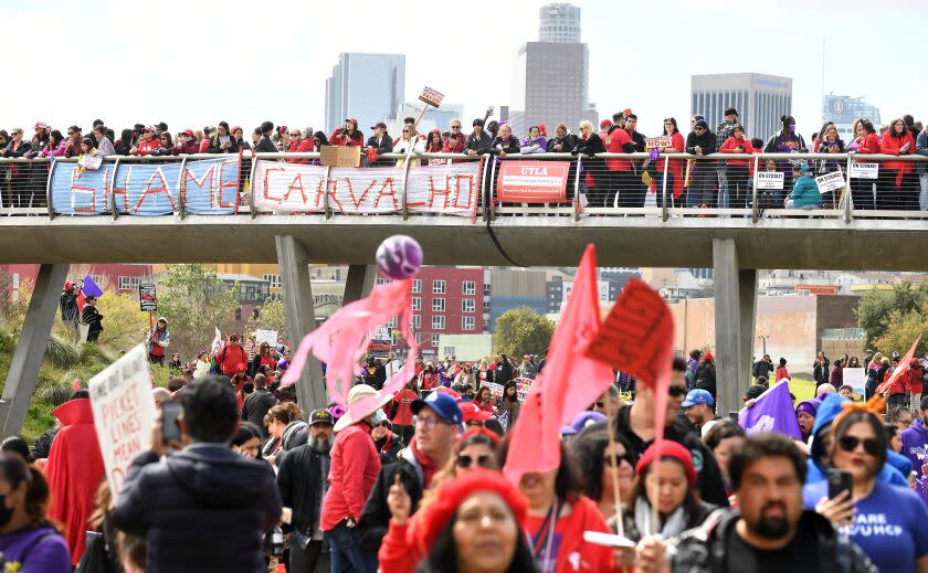 Los Angeles, California March 23, 2023-Protestors stand on a hill with Downtown L.A. in the background as members of the Service Employees International Union Local 99 picket at Los Angeles Historic State Park Thursday. (Wally Skalij/Los Angeles Times)