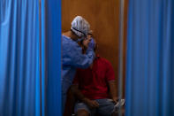 A Spanish NGO Open Arms volunteer takes a swab to test a man for COVID-19, at Vilafranca del Penedes in the Barcelona province, Spain, Tuesday, Aug. 11, 2020. Spain is facing another surge in coronavirus infections not even two months after beating back the first wave. (AP Photo/Emilio Morenatti)