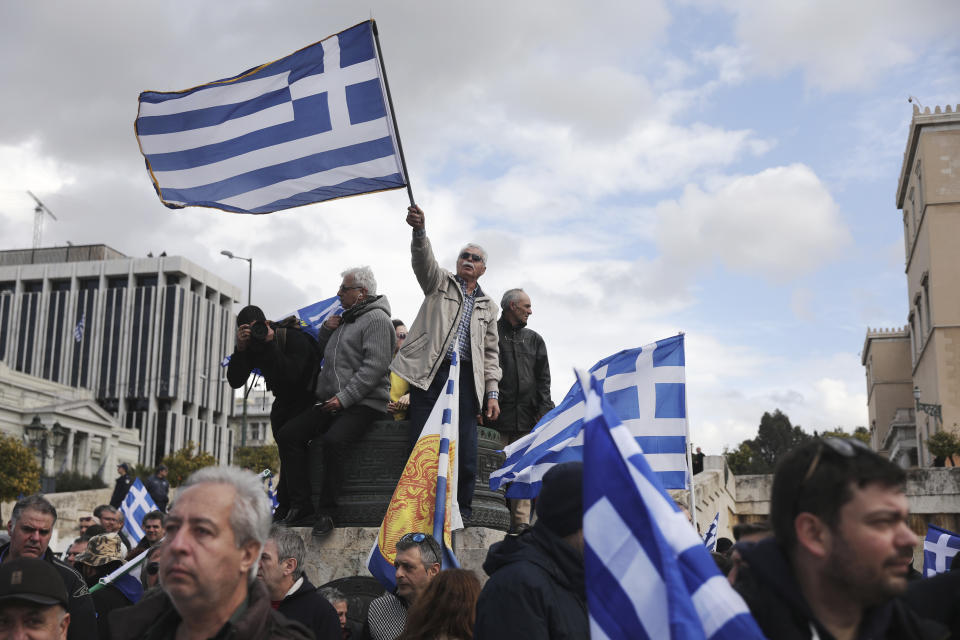 Demonstrators wave Greek flags outside parliament during a rally in Athens, Sunday, Jan. 20, 2019. Greece's Parliament is to vote this coming week on whether to ratify the agreement that will rename its northern neighbor North Macedonia. Macedonia has already ratified the deal, which, polls show, is opposed by a majority of Greeks. (AP Photo/Yorgos Karahalis)