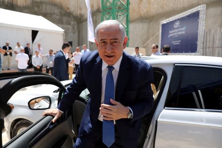 Israeli Prime Minister Benjamin Netanyahu exits an autonomous vehicle during a cornerstone-laying ceremony for Mobileye's center in Jerusalem