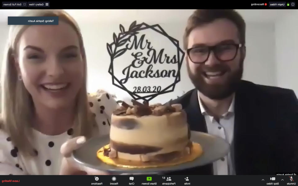 Ben Jackson and Sophie Austin of the school sweethearts holding their wedding cake as they get married over Zoom video chat, after the Coronavirus lockdown made their dream wedding impossible.