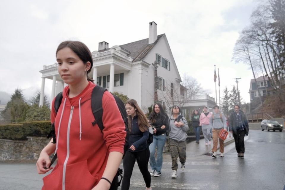 A Juneau-Douglas High Achool student walks past the Governor's Mansion in Juneau during a protest of Gov. Mike Dunleavy's education funding veto on April 4, 2024. (Photo by Claire Stremple/Alaska Beacon)