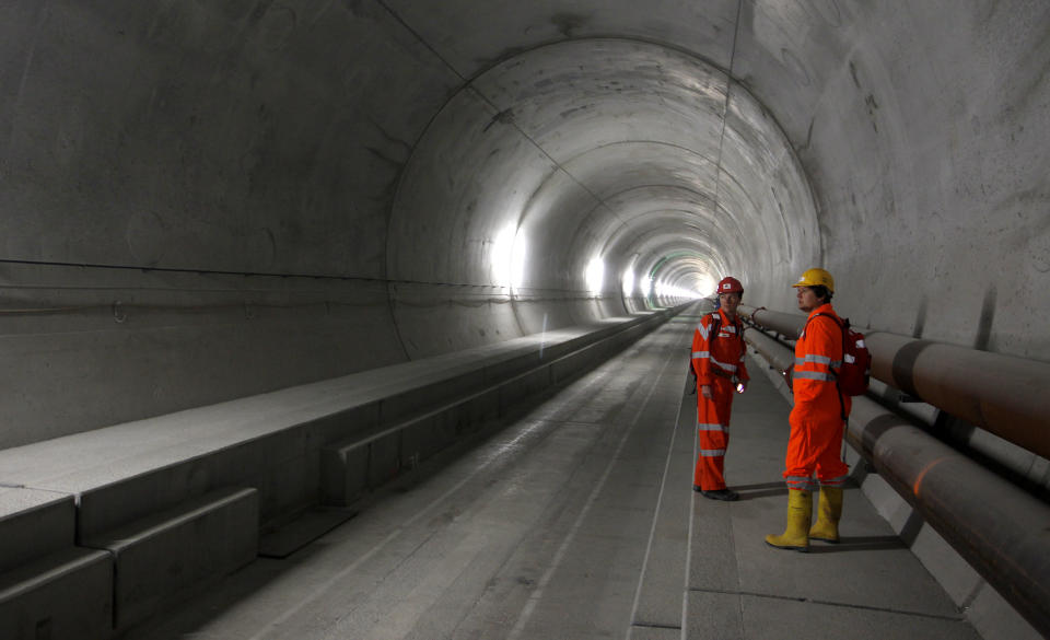 An employee of AlpTransit Gotthard Ltd and a visitor stand at the NEAT Gotthard Base tunnel near Erstfeld