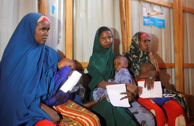 Internally displaced Somali women carry their children as they wait for malnutrition screening at the Dollow hospital in Dollow