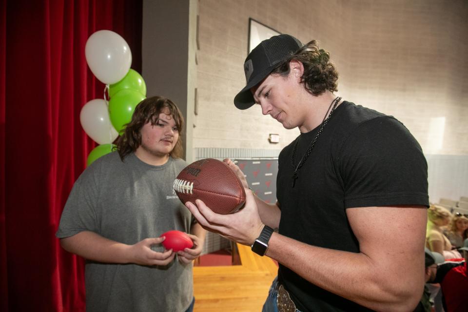 Bradford High School senior Chason Clark signs a football for Dakota Maston after he signs his letter of intent to play football at Marshall University during a program at Bradford High School in Starke, FL on Wednesday, December 20, 2023. Clark, 6’3 and 210 pounds, was a Middle Linebacker and Tight End on this this years team and went to the state championship. [Alan Youngblood/Gainesville Sun]