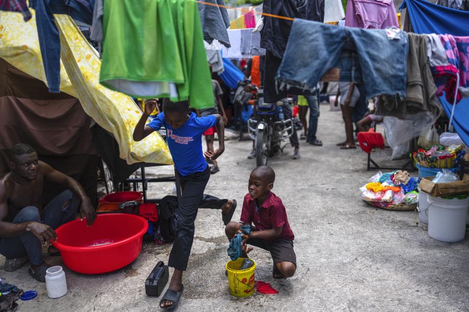 Un niño lava ropa en una escuela pública que sirve de refugio para personas desplazadas de sus hogares debido a los enfrentamientos entre pandillas en Puerto Príncipe, Haití, el lunes 22 de abril de 2024. Hace mucho que el sistema de salud de Haití era frágil, pero ahora se acerca al colapso total después de que las pandillas lanzaran ataques coordinados el 29 de febrero contra infraestructura crítica en la capital y otros lugares.(AP Foto/Ramón Espinosa)