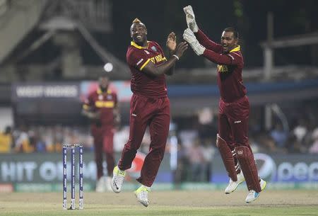 Cricket - England v West Indies - World Twenty20 cricket tournament final - Kolkata, India - 03/04/2016. West Indies Andre Russell celebrates with his teammate Denesh Ramdin (R) after taking the wicket of England's Alex Hales. REUTERS/Rupak De Chowdhuri