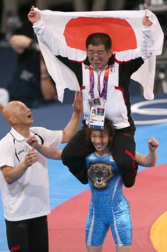 Japan's Saori Yoshida (C) celebrates with her coaches after defeating Canada's Tonya Lynn Verbeek in their women's 55kg freestyle gold medal match during the wrestling event of the London 2012 Olympic Games