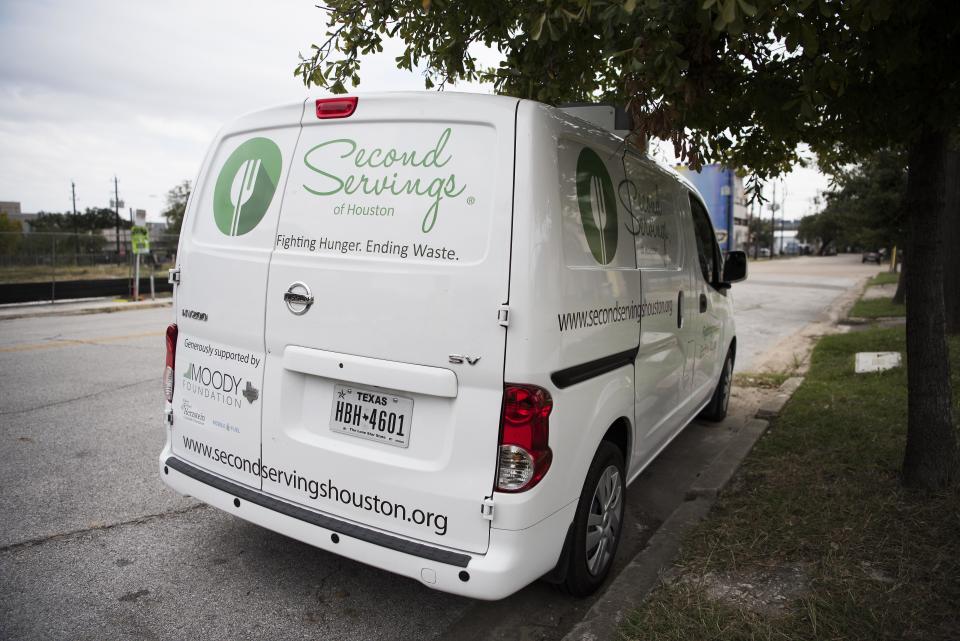 A van owned by "Second Servings," an organization that picks up leftover food and gives it to those in need, is parked at Midtown Park in Houston.