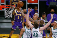 Los Angeles Lakers' Kyle Kuzma (0) goes to basket while defended by Boston Celtics' Luke Kornet (40) during the second half of an NBA basketball game Thursday, April 15, 2021, in Los Angeles. (AP Photo/Ringo H.W. Chiu)