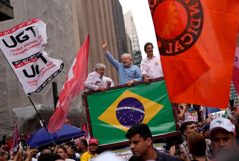 El expresidente de Brasil, Luiz Inacio Lula da Silva, saluda a sus seguidores acompañado por el expresidente de Uruguay, José "Pepe" Mujica y el candidato a gobernador de Sao Paulo, Fernando Haddad, durante un evento de campaña.