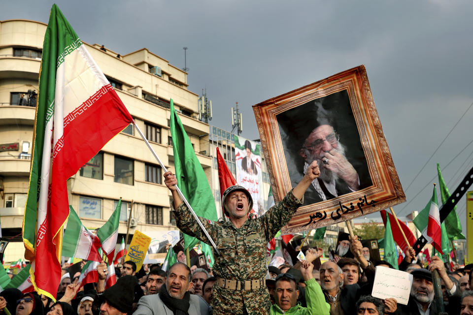 FILE - In a Nov. 25, 2019, file photo, a demonstrator chants slogans while holding up an Iranian national flag during a pro-government rally in Tehran, Iran, denouncing violent protests over a government-imposed fuel price hike. Even among hard-liners in Iran, there seems to be an acknowledgment of one fact after widespread protests, violence and a security force crackdown following government-set gasoline prices spiking: This will not be the last time demonstrators come out on the street. (AP Photo/Ebrahim Noroozi, File)