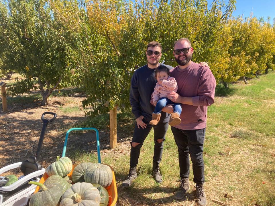 Domenic Marcolongo, left, with his husband Jordan Marcolongo and their daughter Zara at Gilcrease Orchard on Oct. 10, 2021, in Las Vegas.