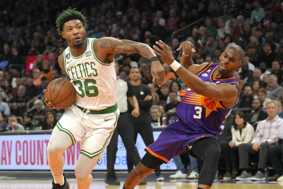 Phoenix Suns guard Chris Paul draws the offensive foul on Boston Celtics guard Marcus Smart (36) during the first half of an NBA basketball game, Wednesday, Dec. 7, 2022, in Phoenix. (AP Photo/Rick Scuteri)