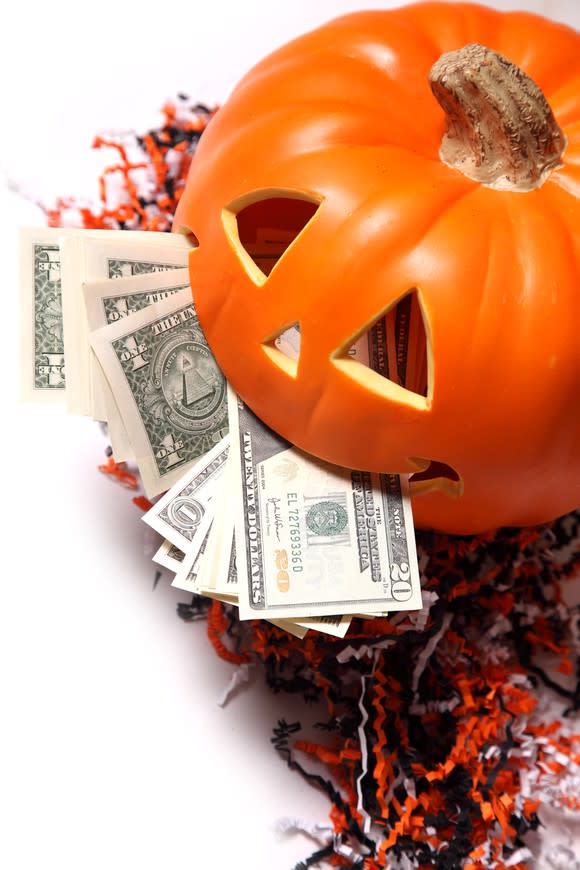 A carved pumpkin full of money.