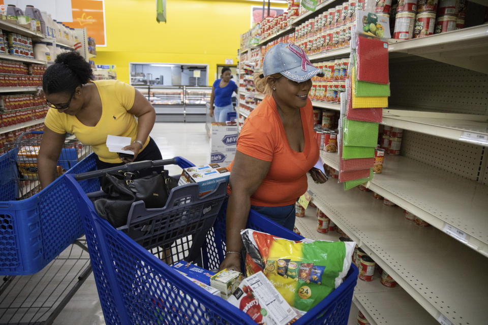 People shop for supplies before the arrival of Hurricane Dorian, in Freeport, Bahamas, Friday, Aug. 30, 2019. Forecasters say the hurricane is expected to keep on strengthening and become a Category 3 later in the day. (AP Photo/Tim Aylen)