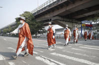 Buddhist monks walk along a road in Seoul, South Korea, Tuesday, Oct. 27, 2020. About 100 monks and believers marched the 500-kilometer (310-mile) pilgrimage to wish for the country to overcome the coronavirus. (AP Photo/Lee Jin-man)