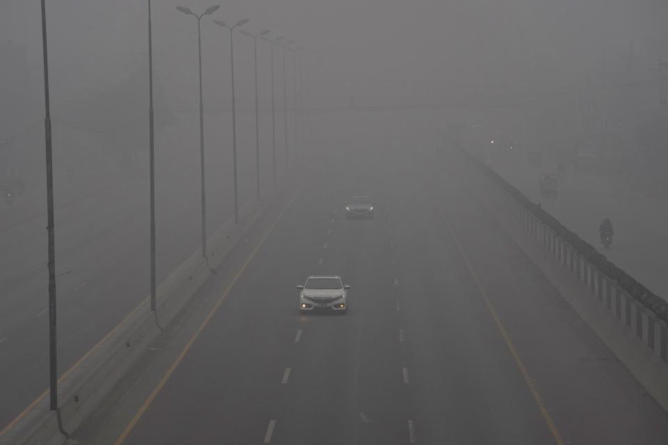 Vehicles drive with headlights on a highway as smog envelops the area and reduces visibility in Lahore, Pakistan, Sunday, Jan. 7, 2024. Toxic smog has sickened tens of thousands of people in recent months. (AP Photo/K.M. Chaudary)