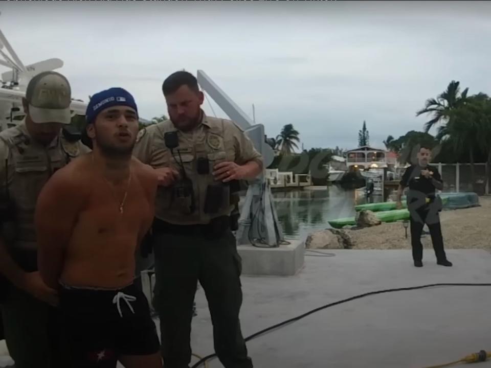 Barrios next to the boat being handcuffed (Donny Rapture / screengrab)