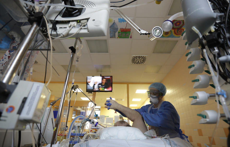 FILE - In this April 7, 2020 file photo a healthcare worker attends to a COVID-19 patient in an intensive care unit (ICU) at the General University Hospital in Prague, Czech Republic. (AP Photo/Petr David Josek, File)