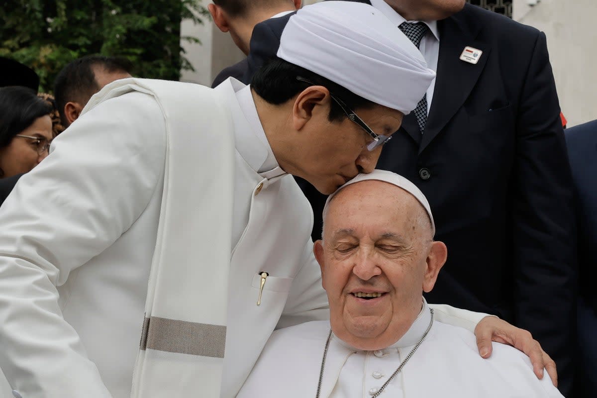 Nasaruddin Umar, left, Grand Imam of Istiqlal Mosque, hugs Pope Francis (AP)