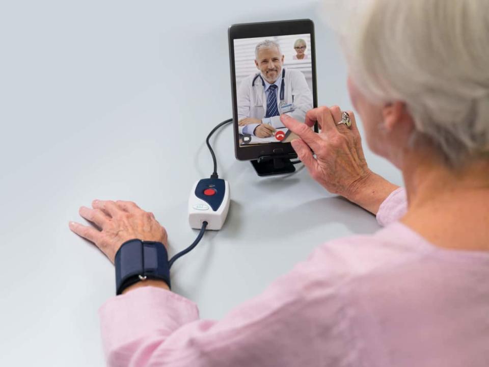 A woman speaks to a medical professional via a tablet in this photo provided by Cloud DX, the Kitchener, Ont., medical software company whose tablets were used to help McMaster University researchers study the impact of remote monitoring on surgery patients. (Cloud DX - image credit)